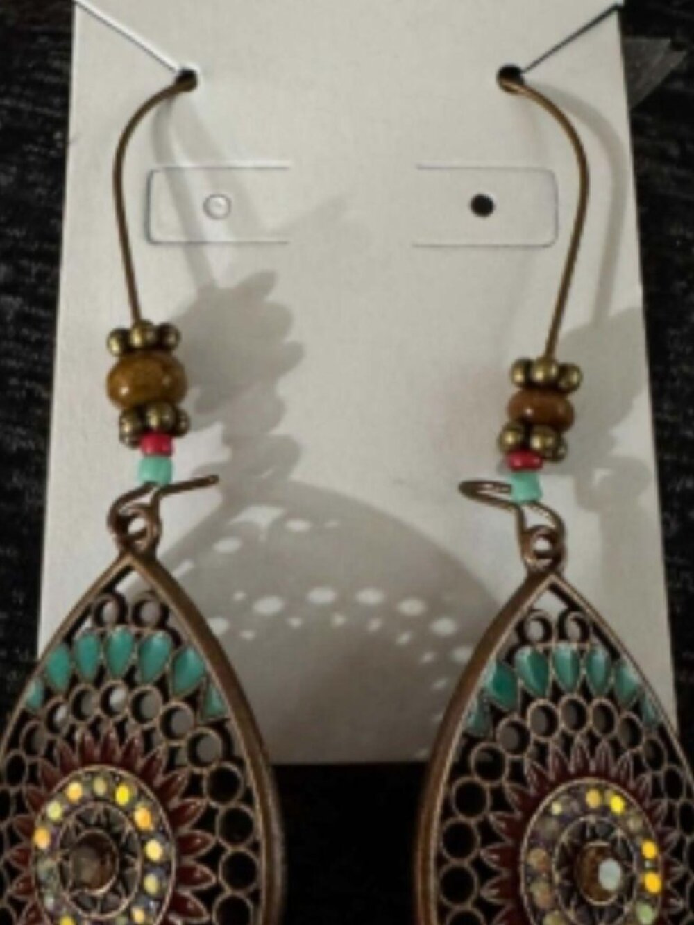intricate openwork teardrop design with an antique bronze-tone finish